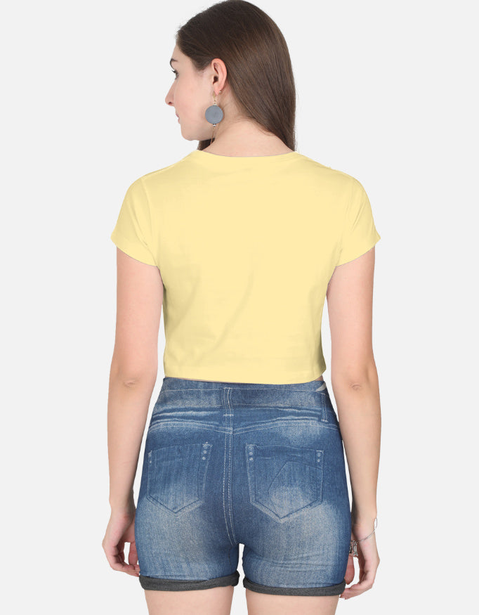 Alpha hue women's crop top in yellow worn by model paired with denim shorts showing back view