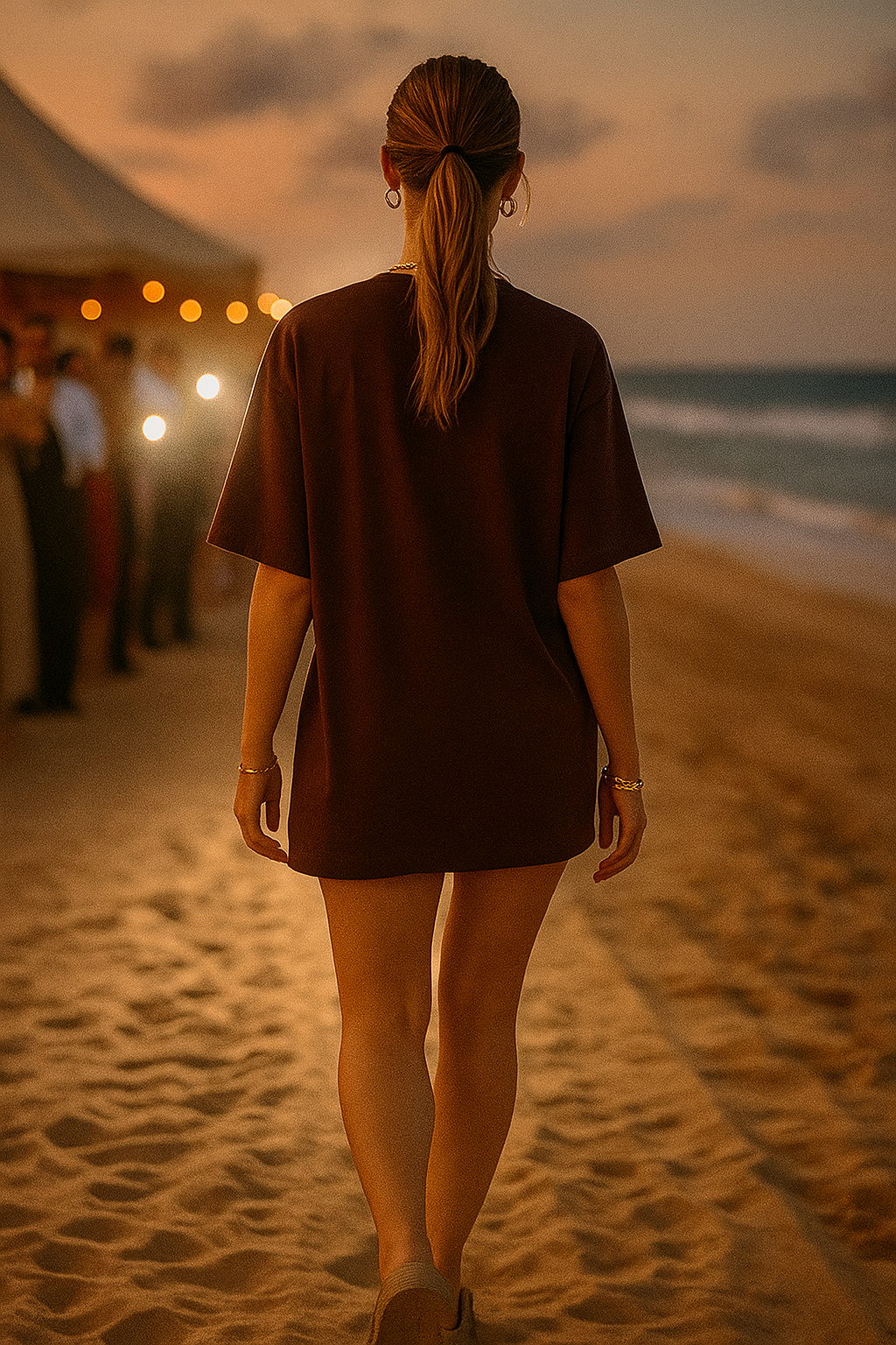 Woman wearing a brown women oversized t-shirt walking on the beach at sunset